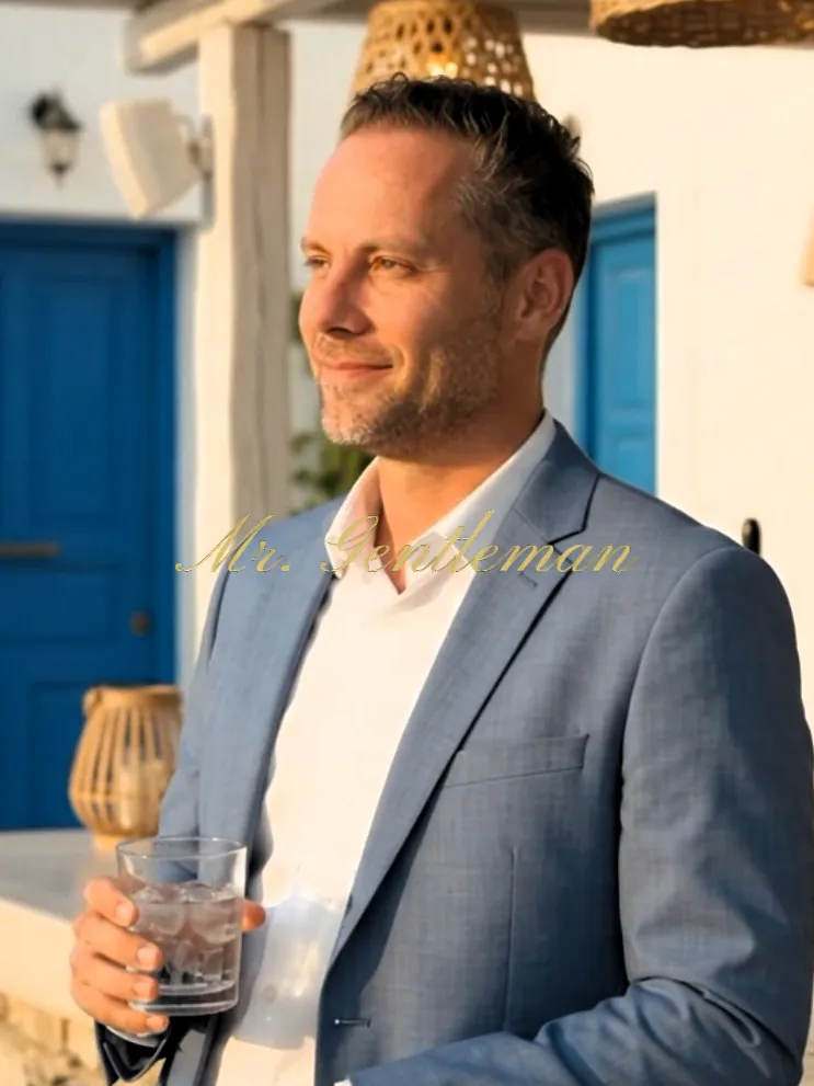 Mr. Gentleman in a blazer with a drink in the evening sun in Crete