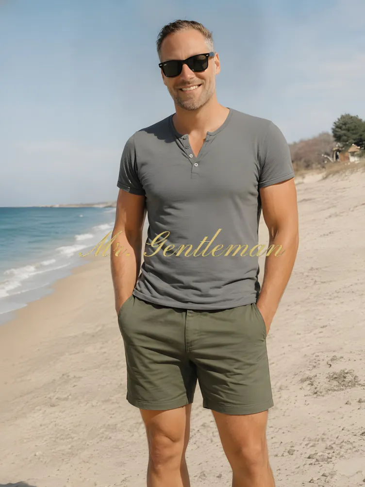 Mr. Gentleman in sunglasses and shorts on a sandy beach in Panormo, Crete