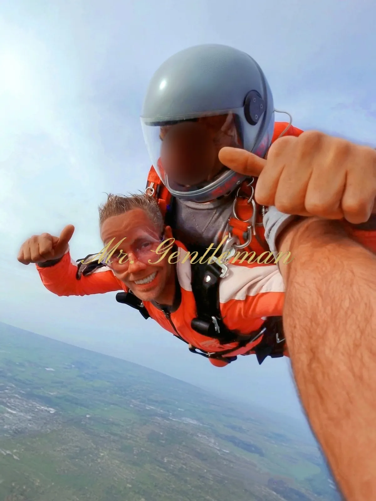 Mr. Gentleman skydiving in tandem, thumbs up